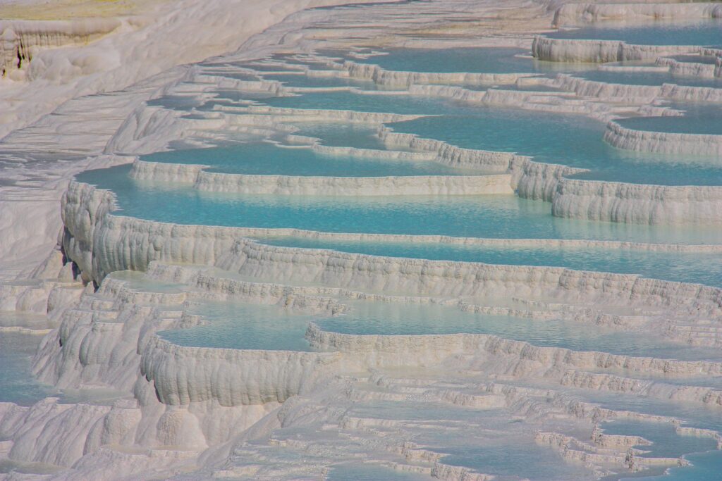 White travertine terraces of Pamukkale with blue mineral pools, Denizli, Türkiye
